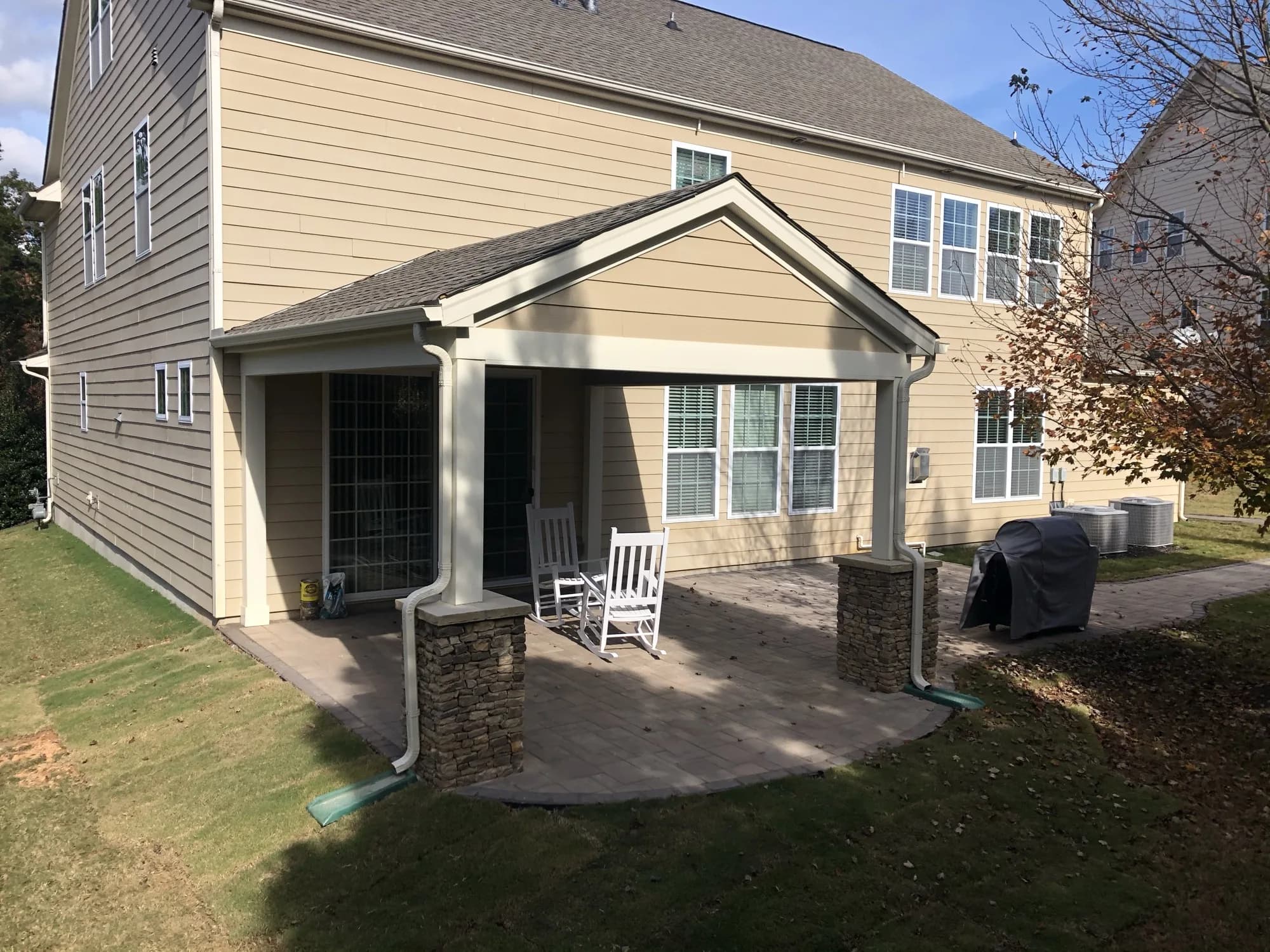 Covered patio with stone columns and rocking chairs built onto a Charlotte, NC home